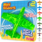 Bright green foam mini glider airplane toy on packaging labeled “Mini Gliders,” suitable for indoor and outdoor play, flies up to 100 ft, ages 4 and up