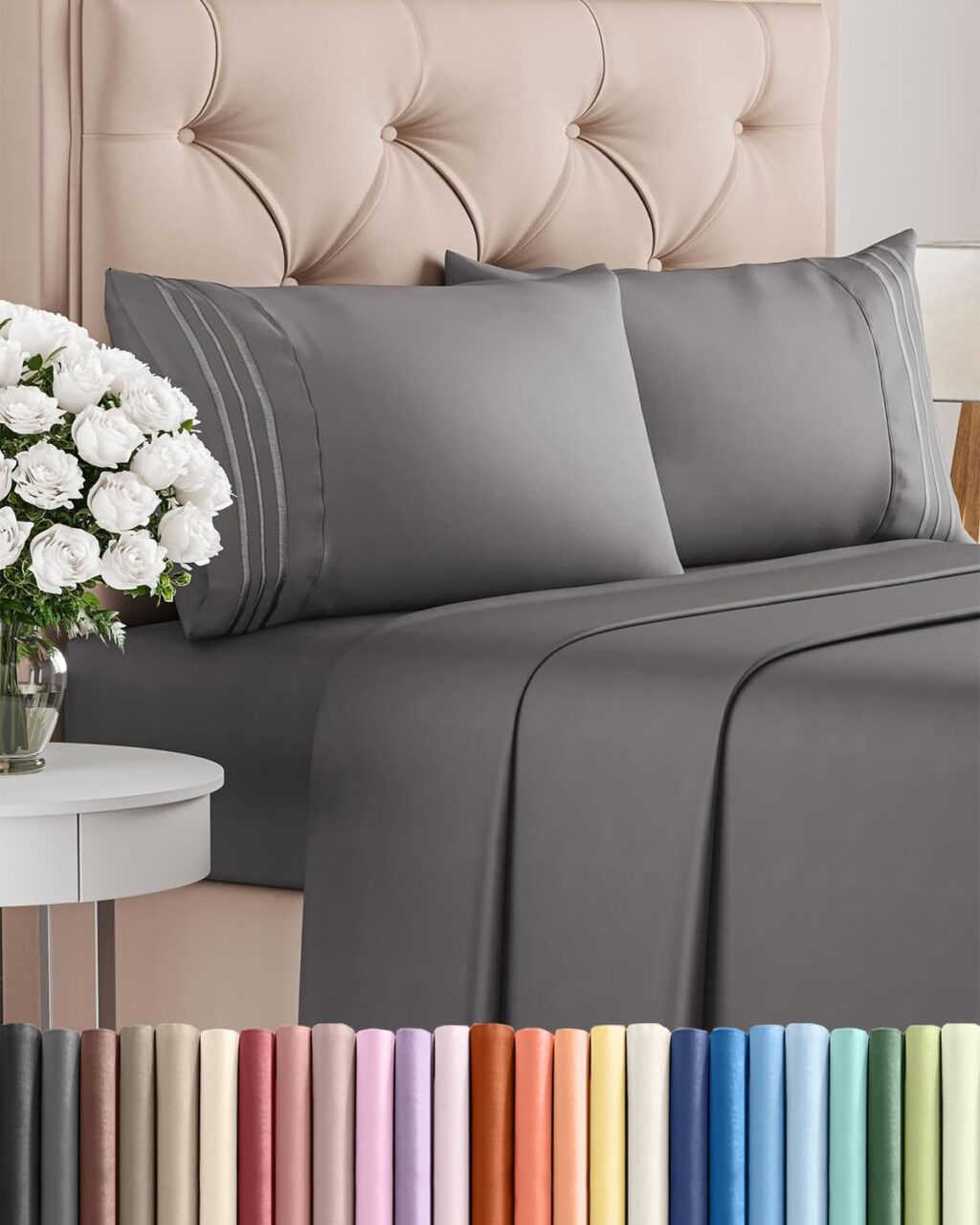 Dark grey queen-size bed sheet set with pillowcases on a tufted beige headboard, styled with a bedside table and white flowers; color options displayed below.