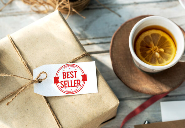 Gift box with best seller tag next to a cup of tea with lemon on a rustic table