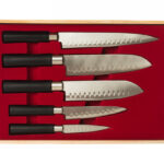 Five kitchen knives in a wooden case with a red velvet interior.