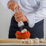 Best salt and pepper shakers comparison showing ceramic, glass, and stainless steel shaker sets from Le Creuset, Menu, and OXO