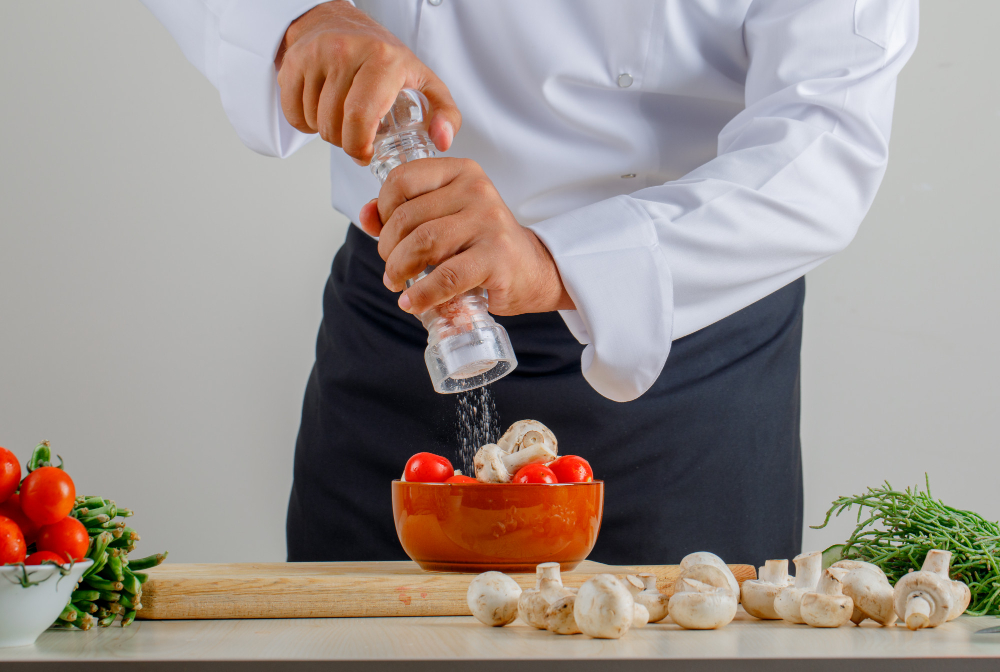 Best salt and pepper shakers comparison showing ceramic, glass, and stainless steel shaker sets from Le Creuset, Menu, and OXO