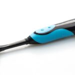 Electric toothbrush with charging base and replacement heads on a bathroom counter