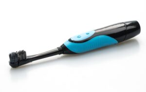 Electric toothbrush with charging base and replacement heads on a bathroom counter
