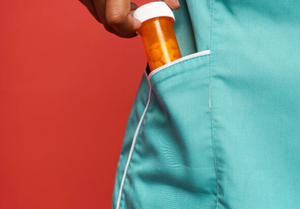 Pill bottle opener tool gripping a medicine bottle cap